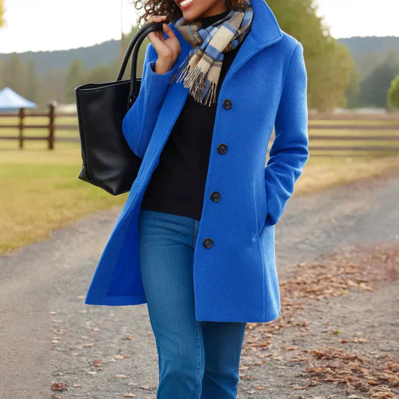 Manteau Aurora Danoir Paris avec un bouton, coupe élégante, tissu chaud, porté en extérieur.