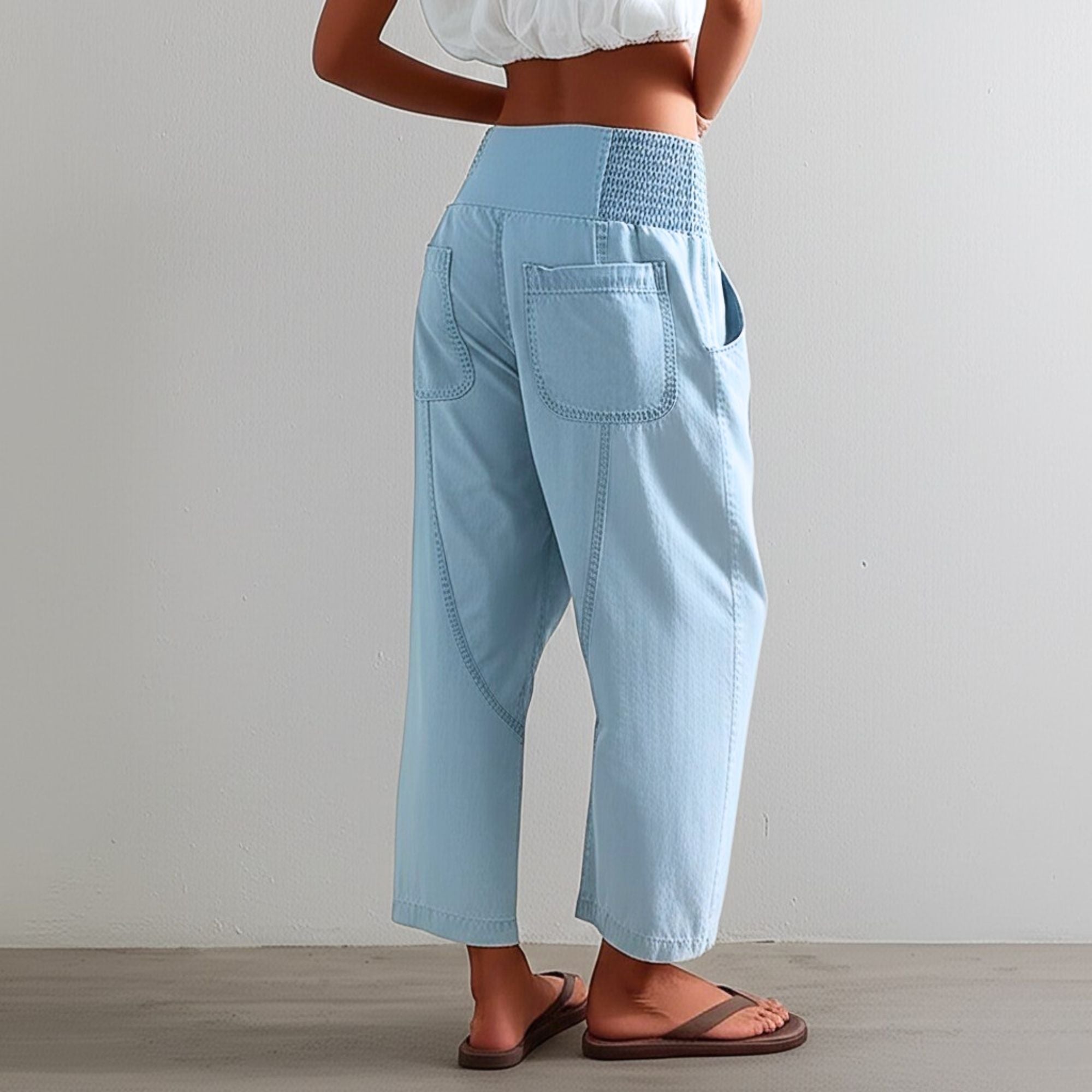 Pantalon Camille de Danoir Paris en tissu léger, coupe ajustée, couleur neutre, porté avec une blouse blanche.
