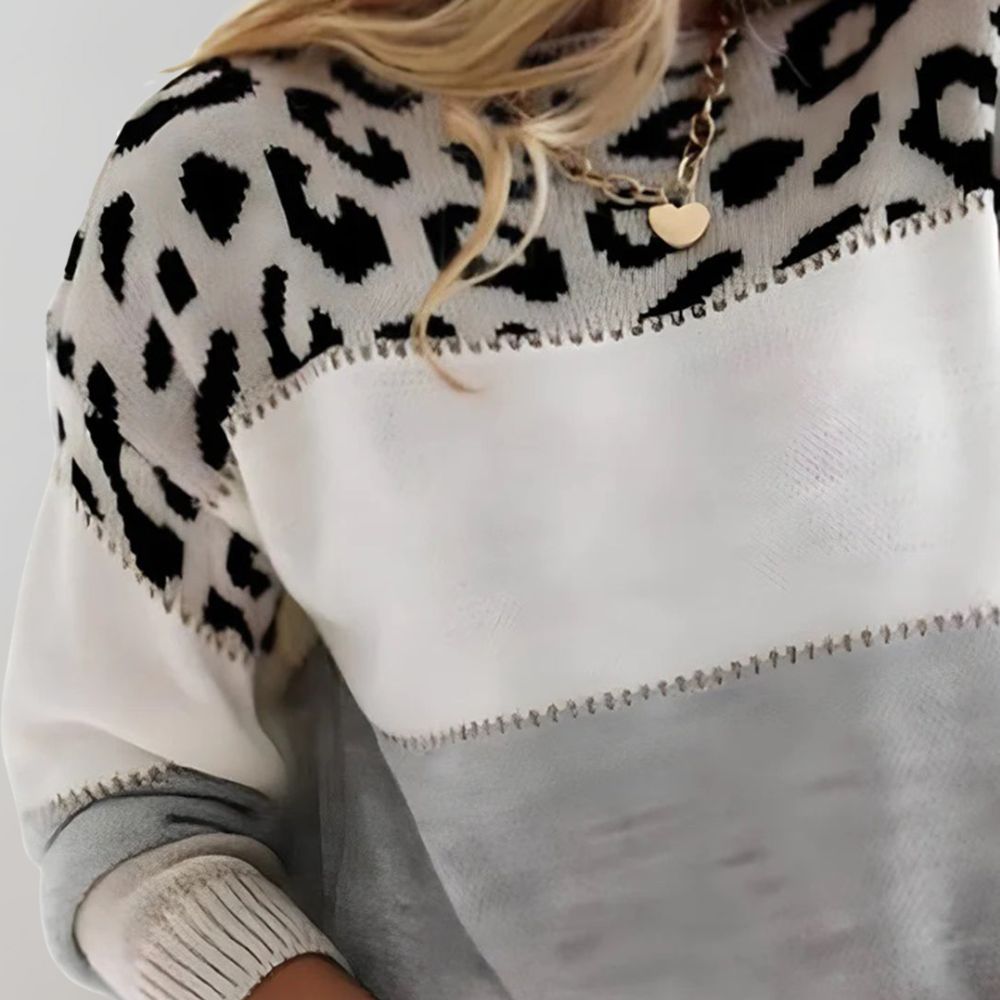 Pull en maille gris avec motif léopard, la mode Diane Laura par Danoir Paris, visible en gros plan sur l'image.
