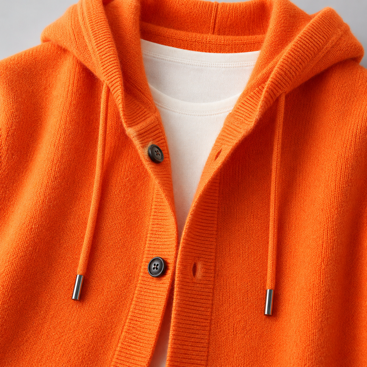 Pull en laine Mavoni avec capuche et boutons de la marque Danoir Paris, visible avec détails de la texture et de la capuche.
