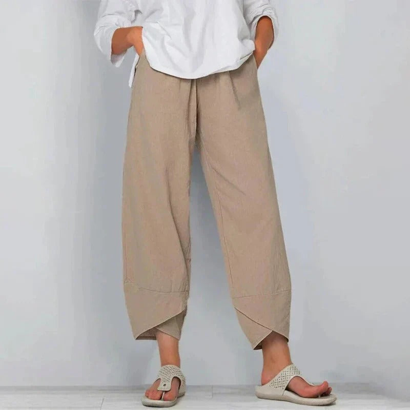 Pantalon d'été chic Garance de Danoir Paris en tissu léger, couleur nude, porté avec une blouse blanche.