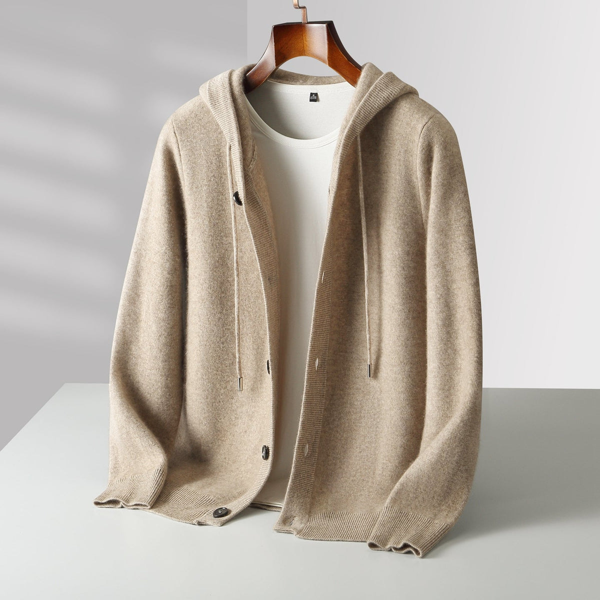 Cardigan à capuche en laine Danoir Paris avec boutons, vue de face, couleur neutre, texture douce et détails de la capuche.