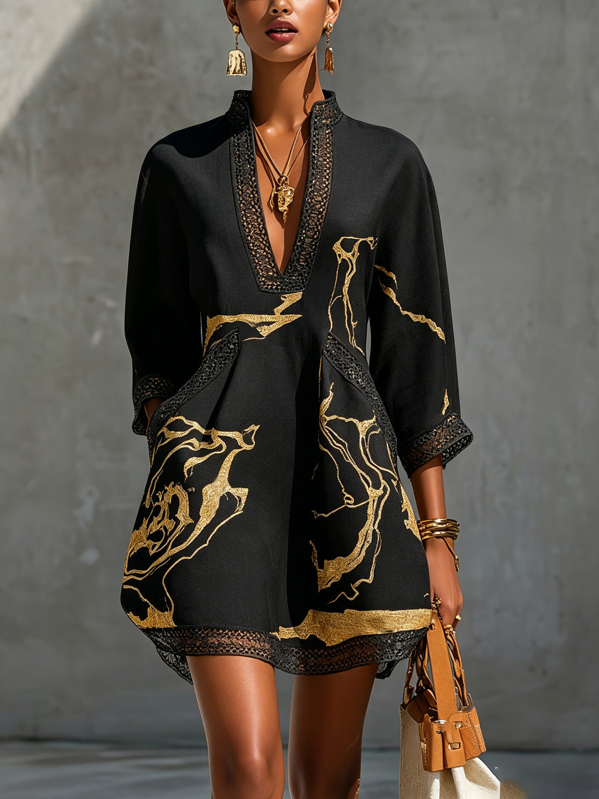 Robe noire courte Dorothée Danoir Paris avec imprimé marbré doré et détails en dentelle crochet, vue de face.