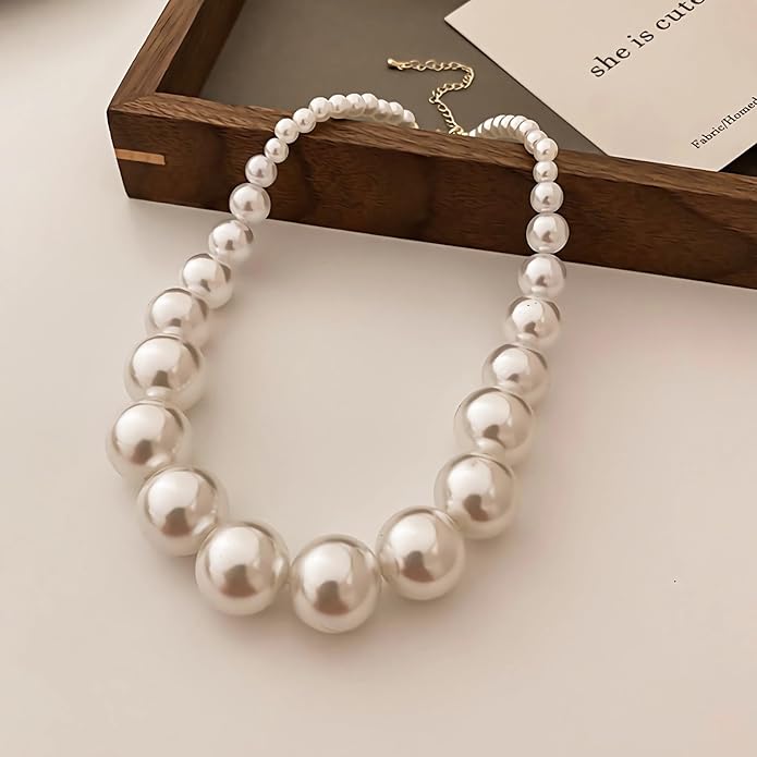 Ensemble de bijoux vintage en perles classiques de la marque Danoir Paris, comprenant des boucles d'oreilles et un collier en perles.