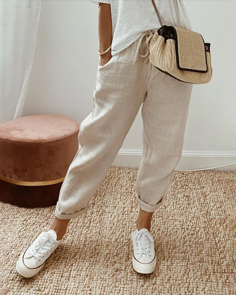 Pantalons fluides Danoir Paris, confortables et élégants, en tissu léger, porté avec une blouse blanche.