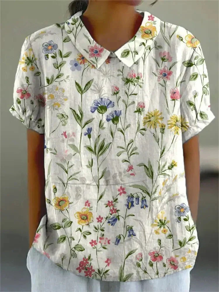 Chemise fleurie élégante Sofia de Danoir Paris, tissu léger avec motifs floraux colorés, portée pour une allure chic et féminine.