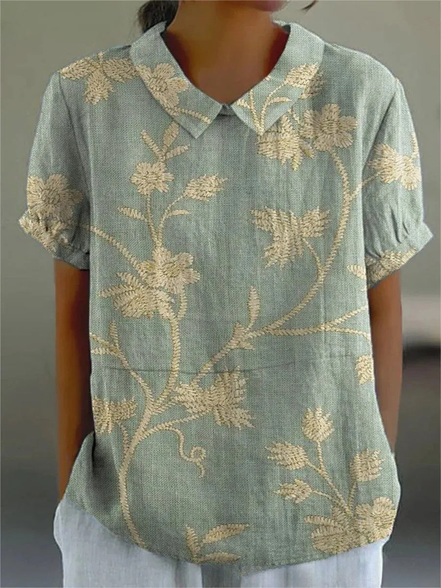 Chemise fleurie élégante Sofia de Danoir Paris, tissu léger avec motif floral, portée avec col et manches longues.