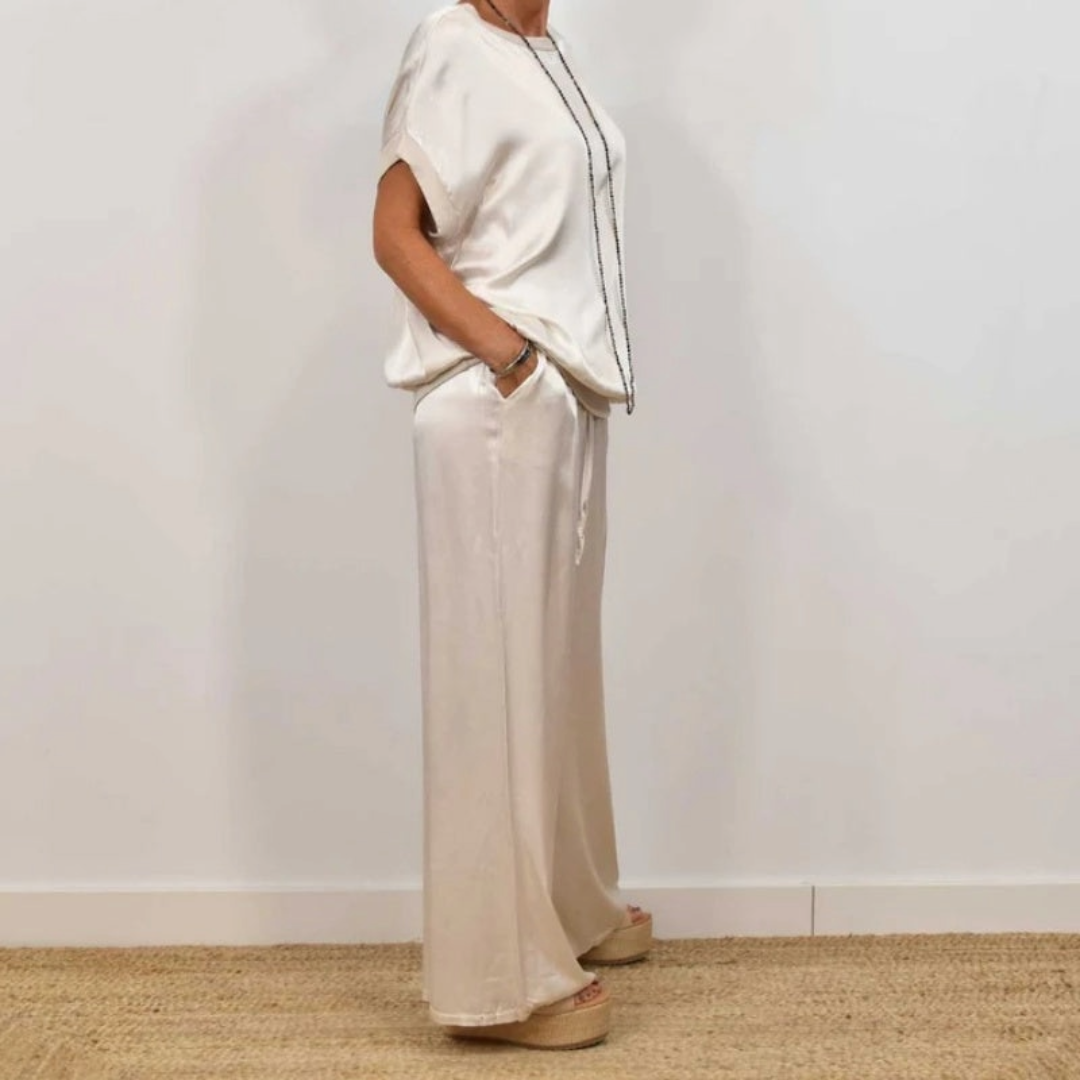 Ensemble élégant à deux pièces Celia de Danoir Paris, comprenant une veste et une jupe en tissu fluide beige.