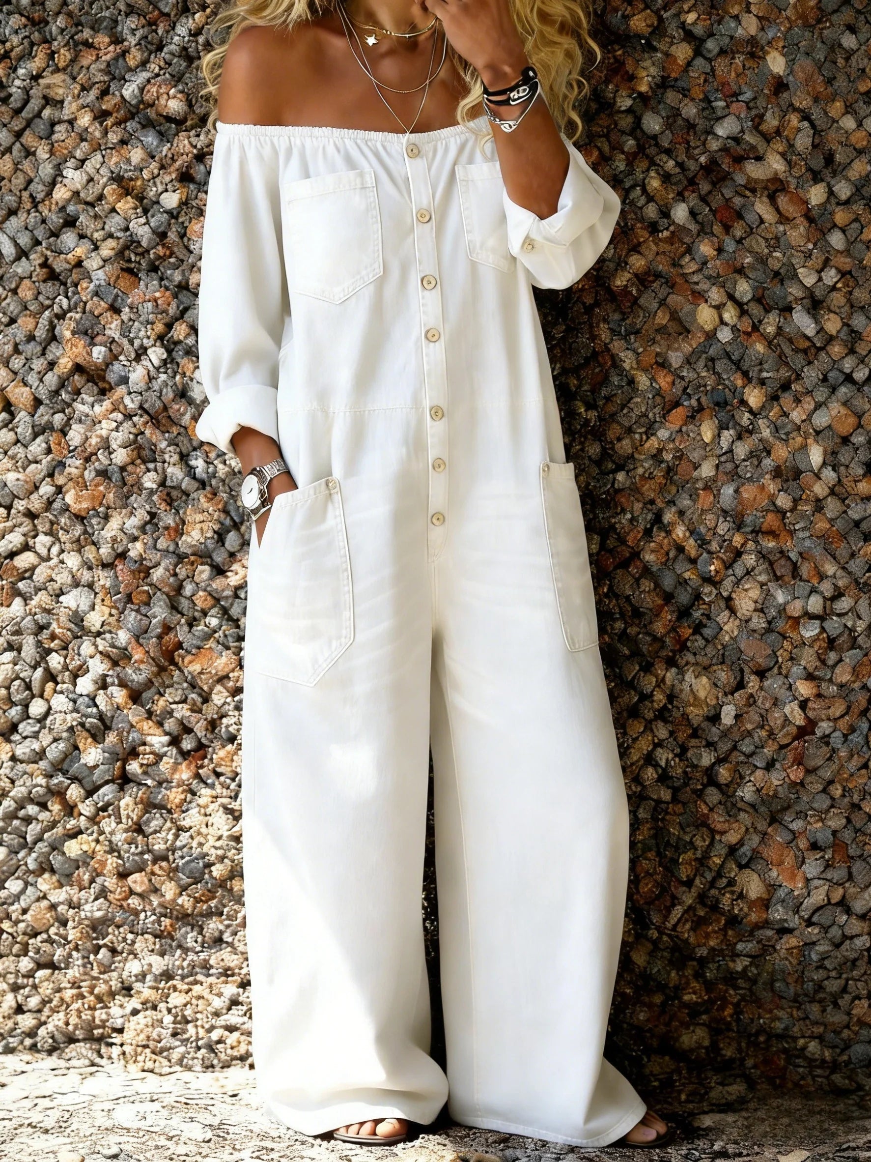 Combinaison en denim Noa de Danoir Paris avec décolleté off-shoulder, ajustée et tendance, portée sur un fond neutre.