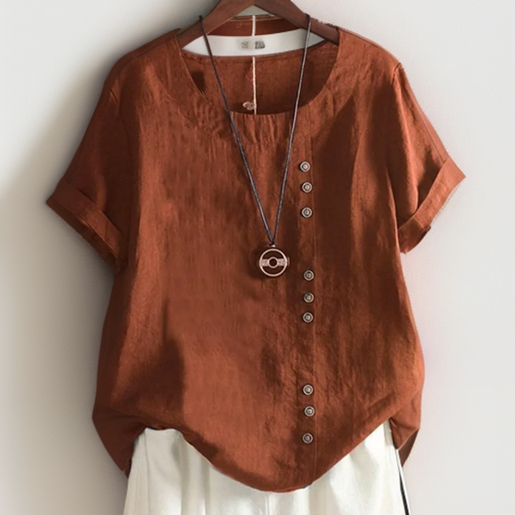 T-shirt chic Isla de Danoir Paris avec boutons, en coton blanc, porté avec d'autres vêtements élégants.