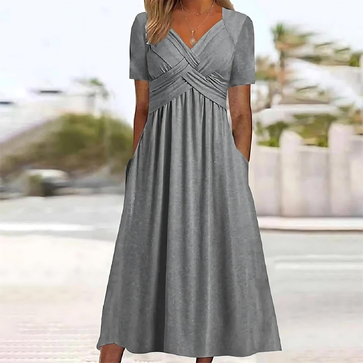 Robe longue élégante Nadine de Danoir Paris en tissu bleu, portée avec détails sophistiqués et coupe fluide.