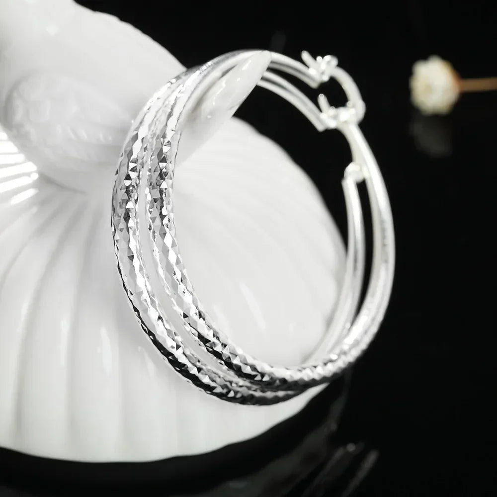 Boucles d'oreilles en argent sterling Danoir Paris avec design élégant, visibles en gros plan sur fond neutre.