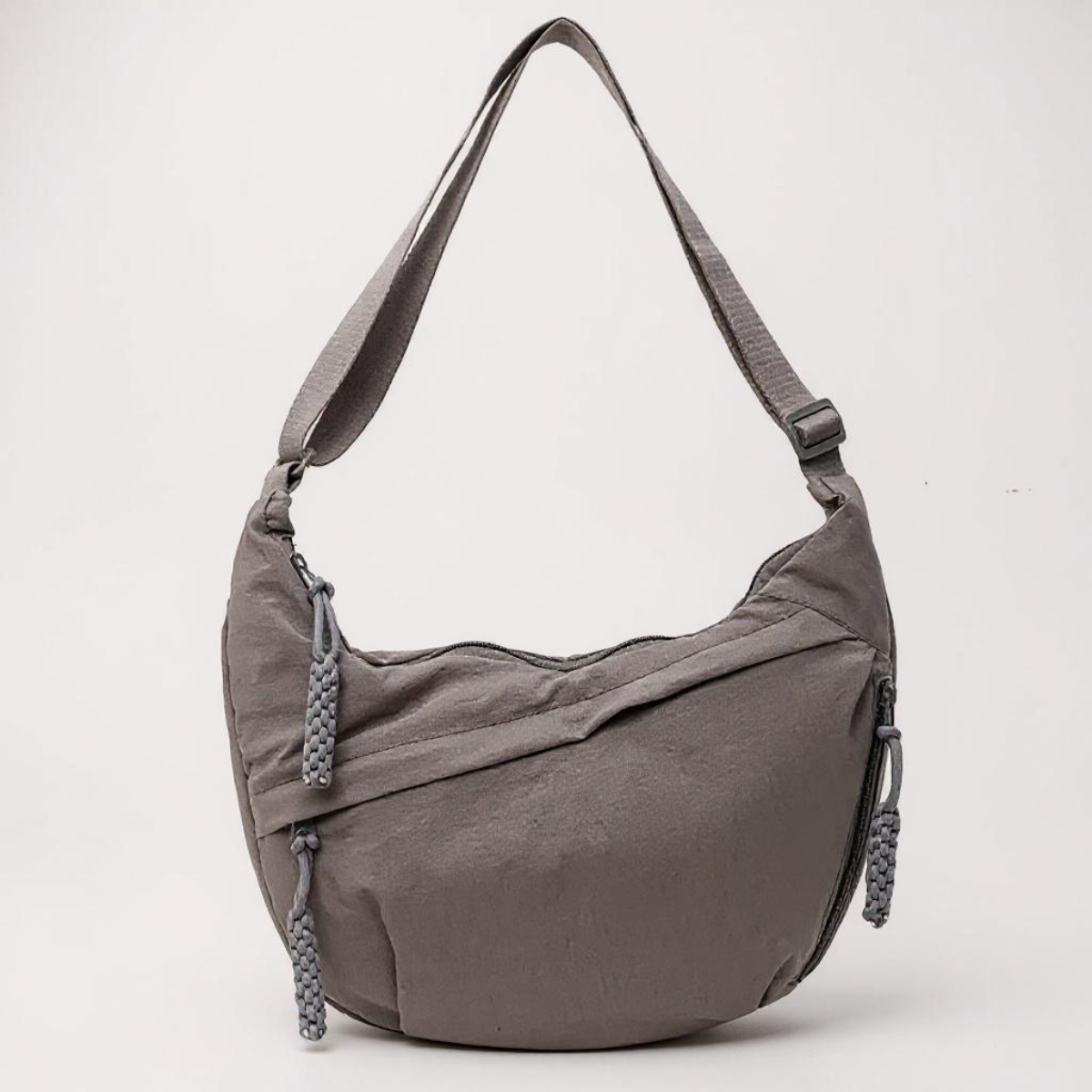 Sac à bandoulière gris Chiara de Danoir Paris, avec poignées en cuir et détails élégants, posé sur fond neutre.