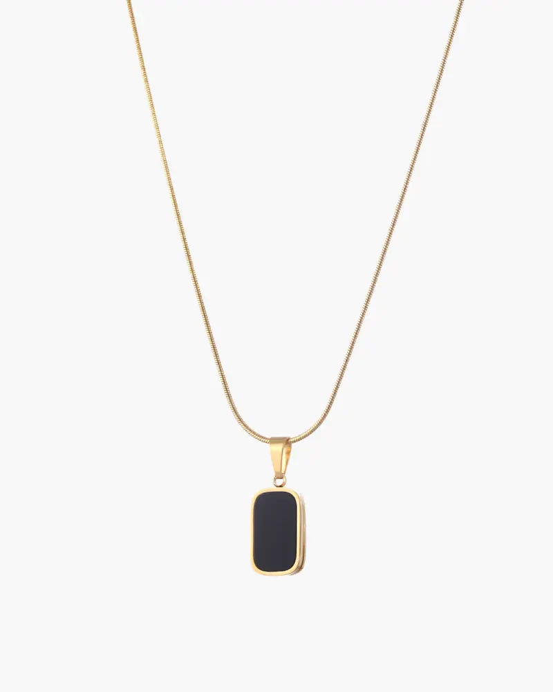 Collier noir Danoir Paris en acier inoxydable avec pendentif élégant, porté sur un fond neutre.