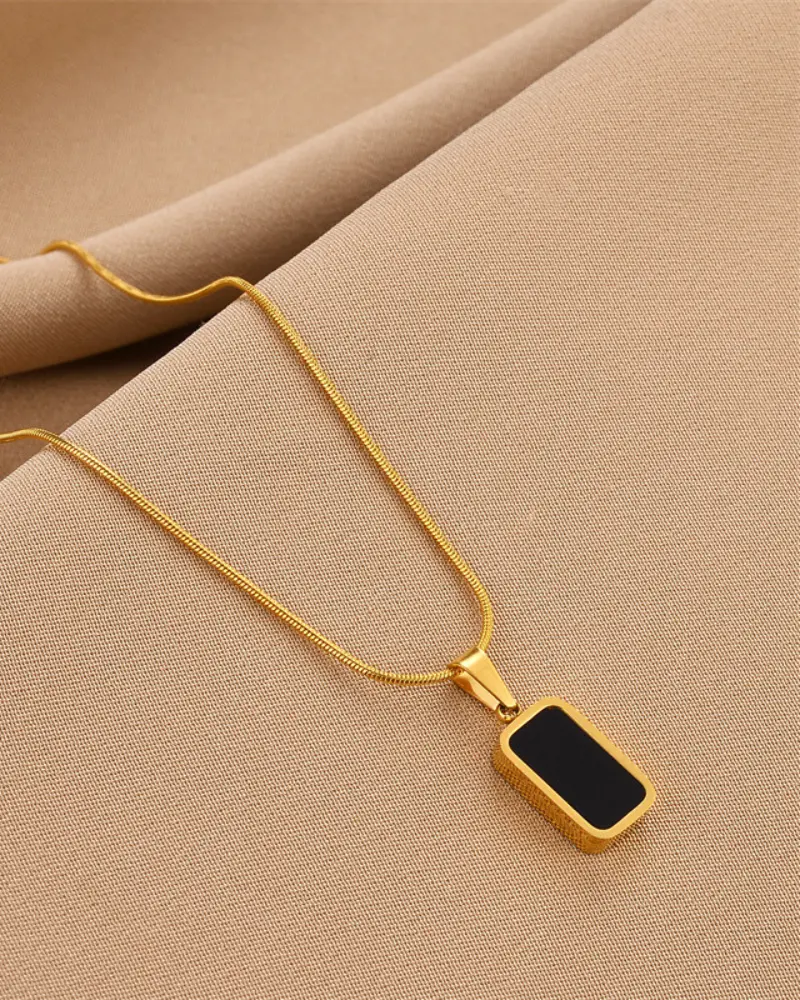Collier noir Danoir Paris avec pendentif élégant en forme de cercle, porté sur un fond clair.