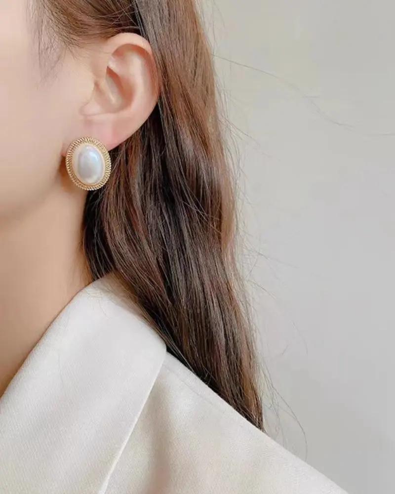 Boucles d'oreilles rondes ovales en perles radiantes de Danoir Paris, élégantes et sophistiquées, visibles en gros plan.