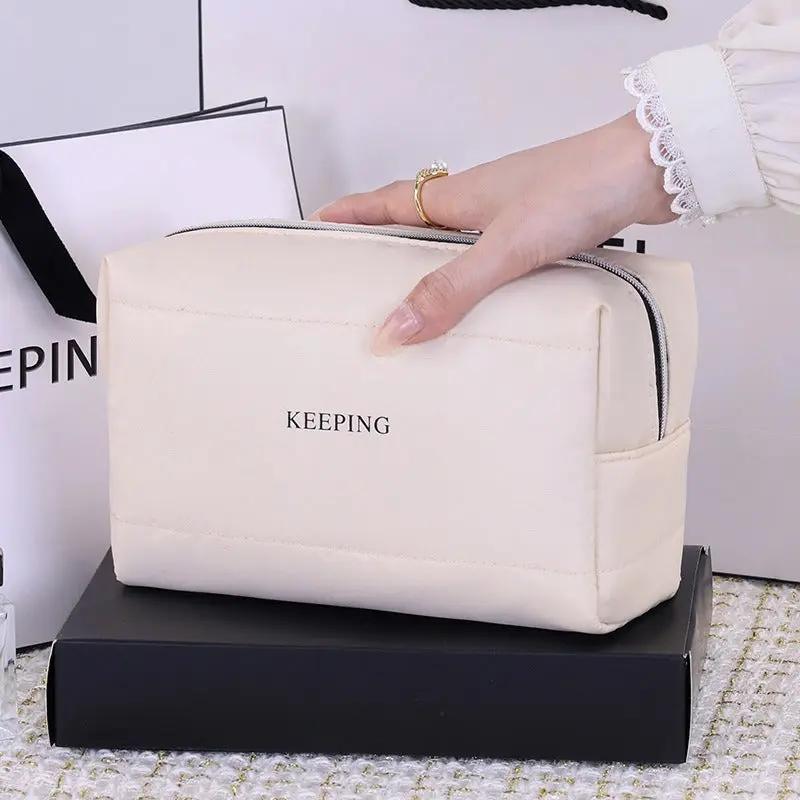 Sac à main Danoir Paris, toilettas élégante en tissu noir avec compartiments pour accessoires de toilette.