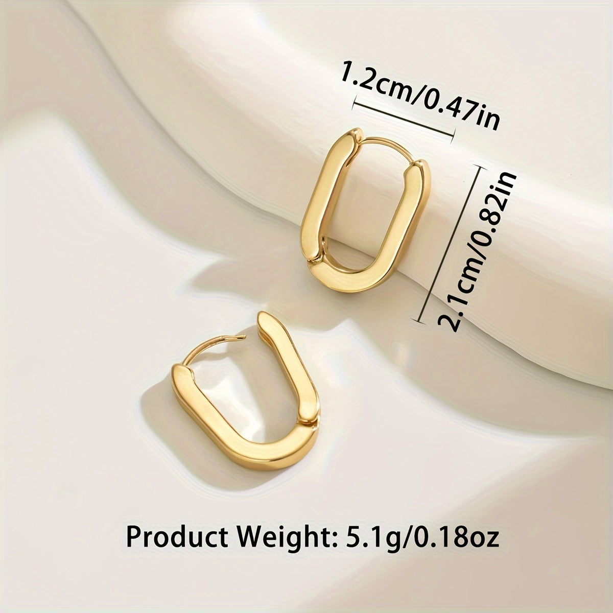 Boucles d'oreilles créoles élégantes de forme géométrique Danoir Paris, en métal doré, avec design moderne et sophistiqué.