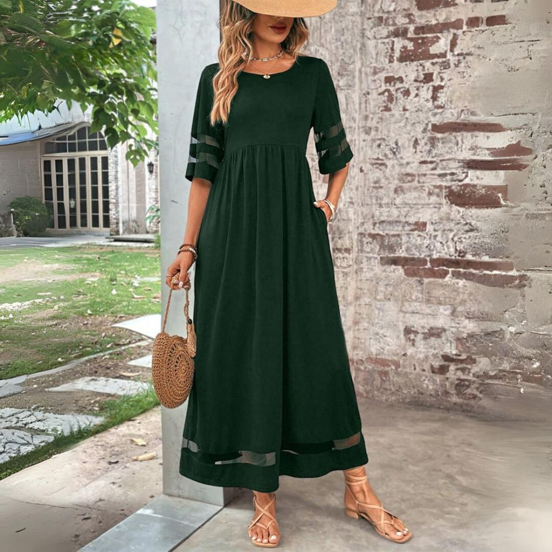 Robe midi Aubrée de Danoir Paris, coupe flatteuse, en tissu léger, portée avec manches longues et décolleté élégant.