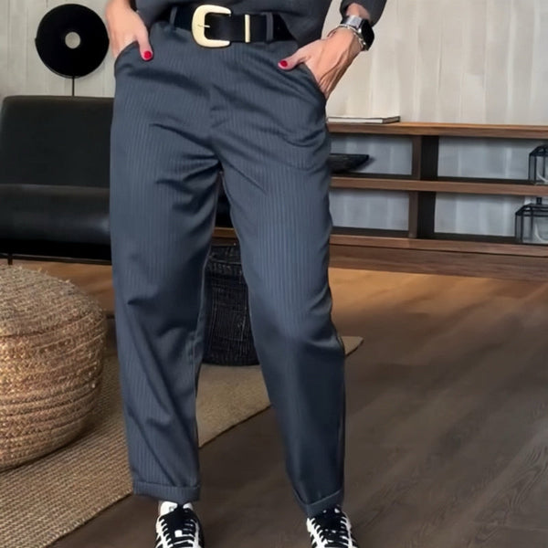 Pantalon élégant polyvalent Mathilda de Danoir Paris, coupe moderne, tissu fluide, couleur neutre, porté avec chemise blanche.