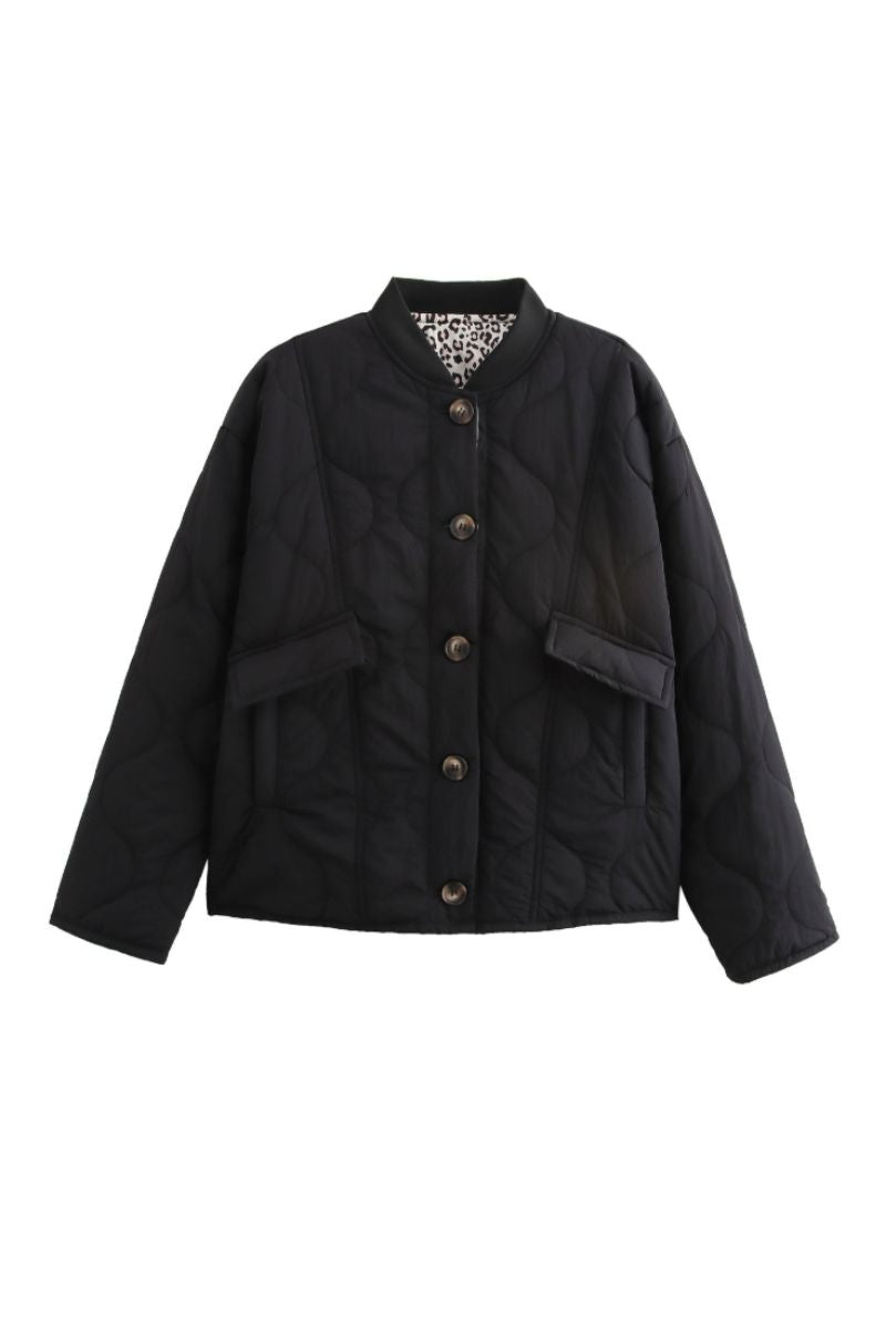 Veste matelassée moderne Noemi™ de Danoir Paris, en tissu noir avec col montant et fermeture éclair visible.