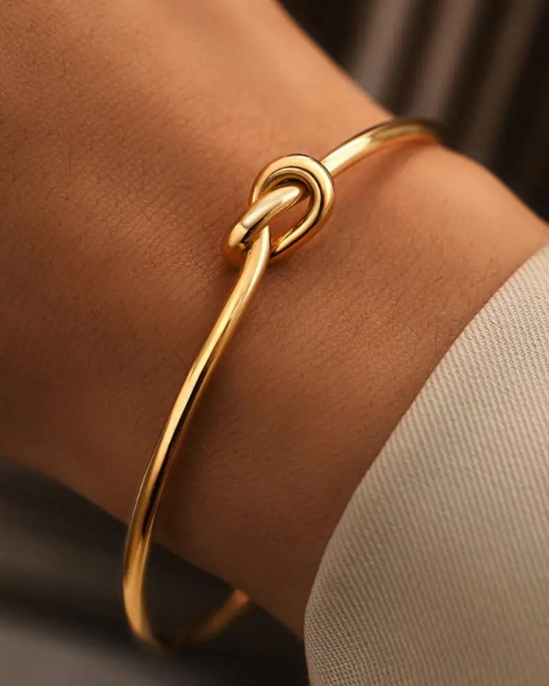 Bracelet nœud éternité en or Danoir Paris, bijou délicat avec motif entrelacé visible sur l'image.