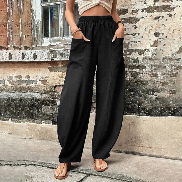 Pantalons fluides Vanna de Danoir Paris en tissu léger, couleur neutre, portée décontractée avec ceinture à la taille.