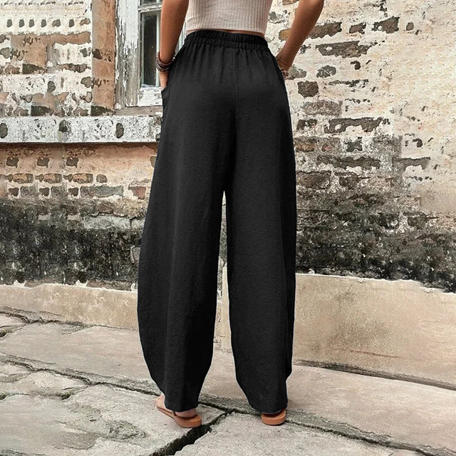 Pantalons fluides Vanna de Danoir Paris, coupe élégante et confortable, en tissu léger, portés avec une blouse blanche.