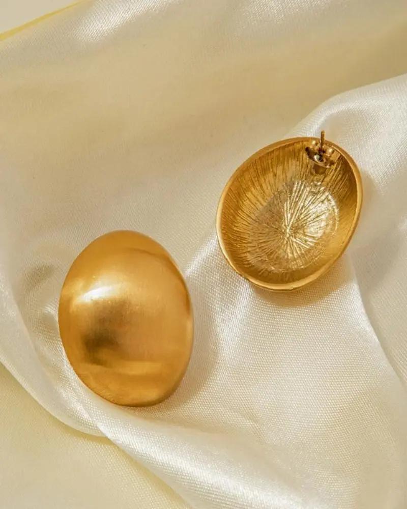 Boucles d'oreilles Orova Shield de Danoir Paris avec design élégant en or, visibles en gros plan sur fond neutre