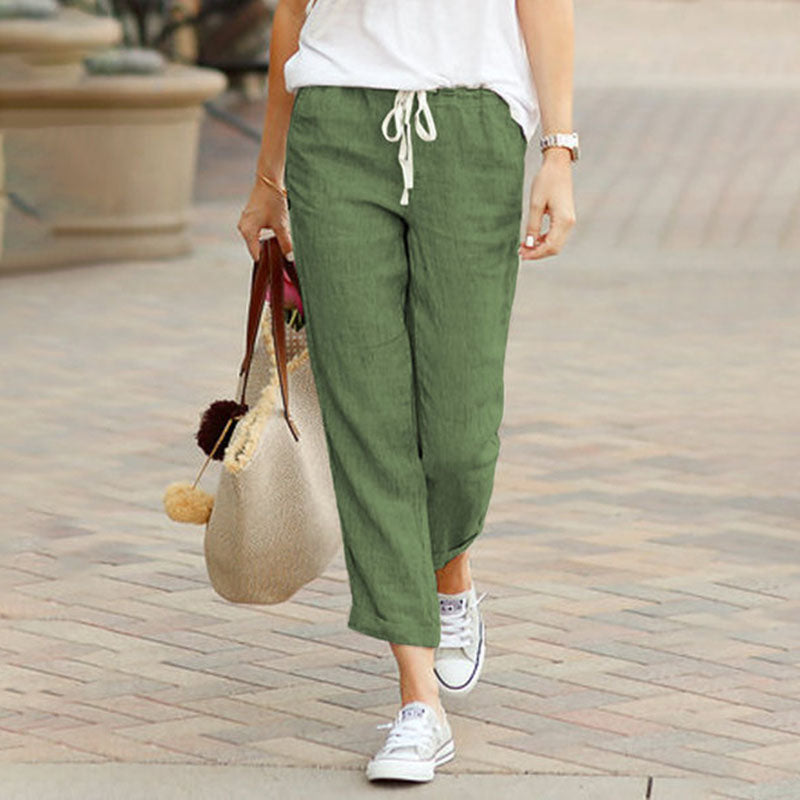 Pantalons casual Alvie de Danoir Paris, coupe confortable, tissu léger, en couleur neutre, porté avec une chemise blanche.