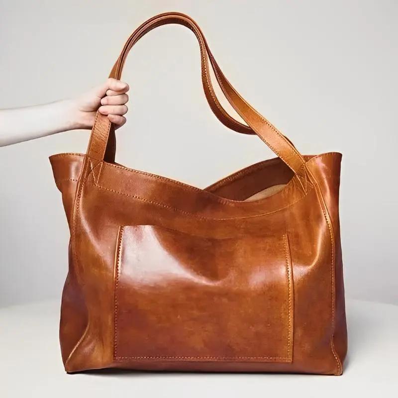Sac en cuir rétro Élise de Danoir Paris, avec poignées en cuir et détails vintage, posé sur un fond neutre.