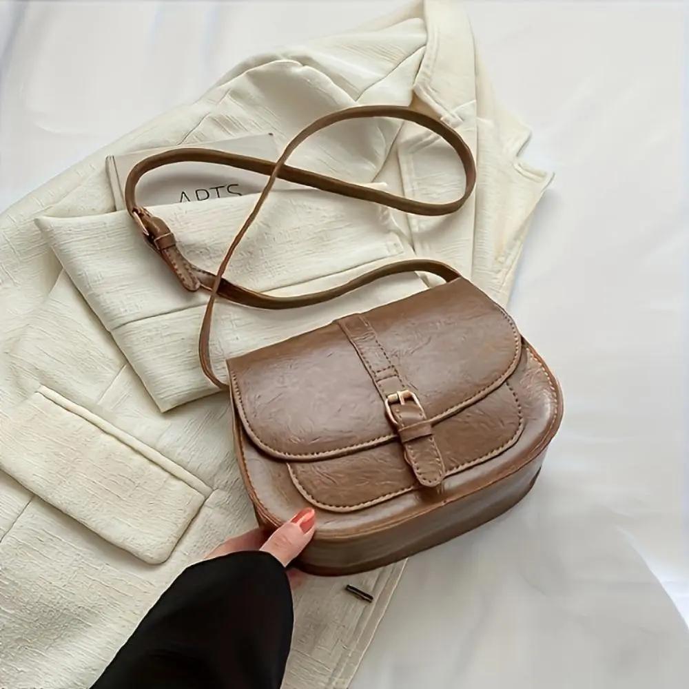 Sac à main Sienna de Danoir Paris, intemporel, en cuir beige avec poignées et fermeture métallique visible.
