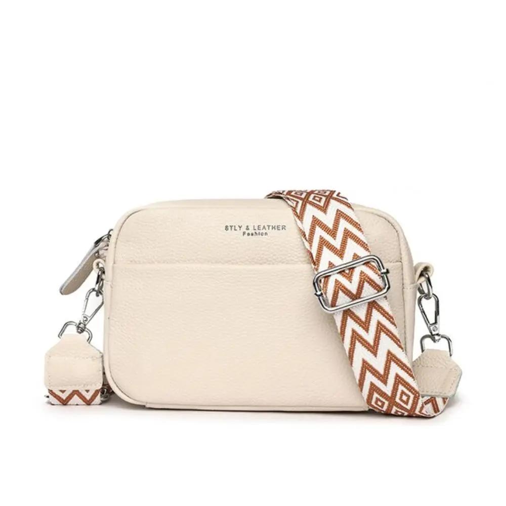 Sac à bandoulière élégant Danoir Paris en cuir de vache, porté croisé, pour femmes, couleur neutre.