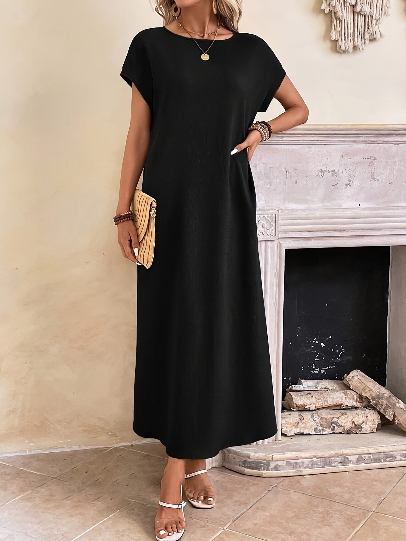 Robe longue élégante et minimaliste Margaux™ de Danoir Paris, en tissu fluide, portée sur un mannequin dans un intérieur moderne.
