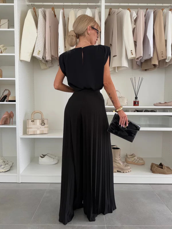 Pantalon chic et confortable Danoir Paris en viscose noire avec plis, style élégant, porté avec une blouse blanche.