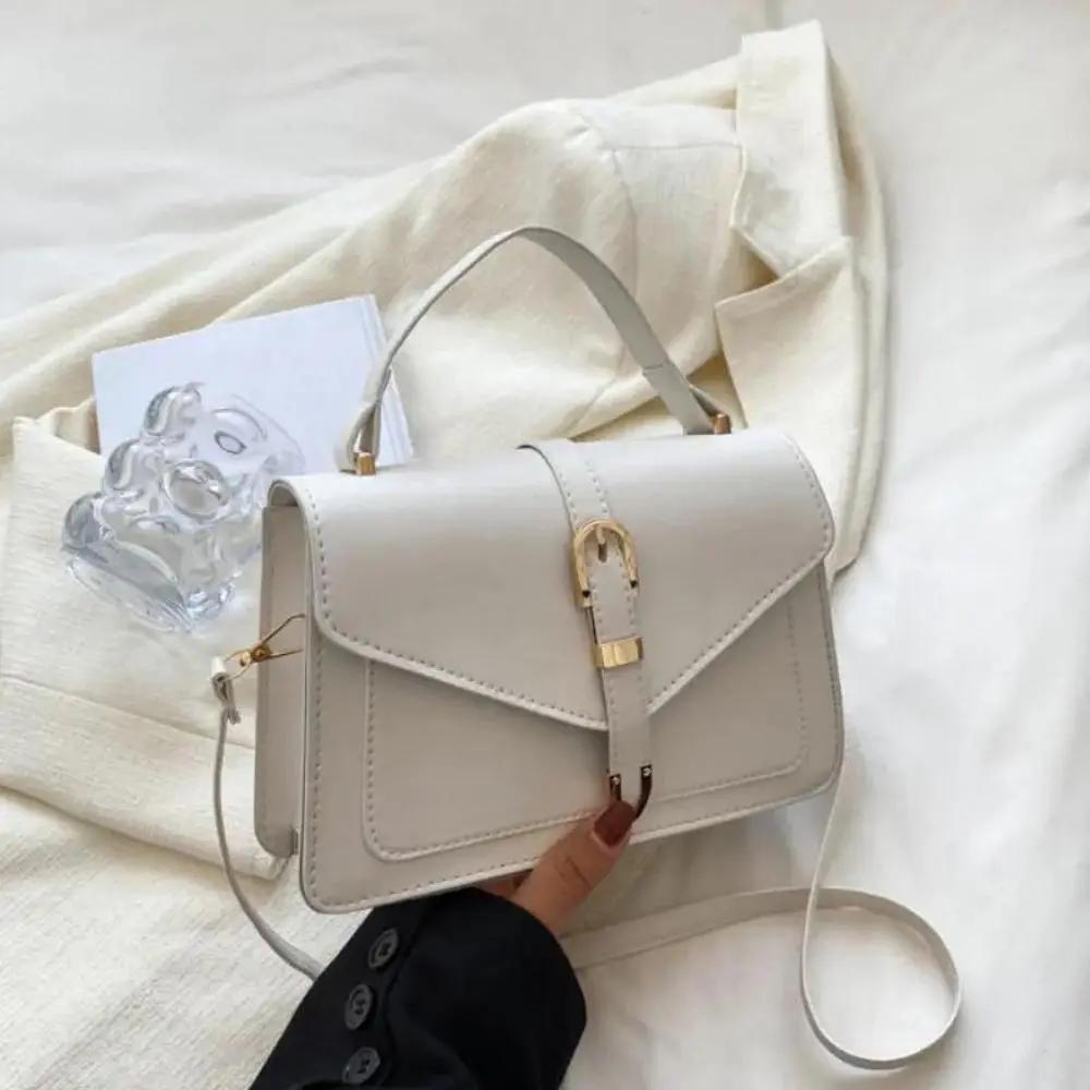 Sac à bandoulière Tessa de Danoir Paris, élégant et minimaliste, en cuir noir avec bandoulière réglable, vue de face.
