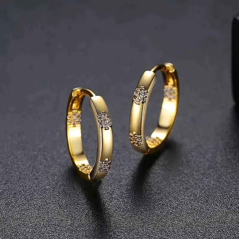 Boucles d'oreilles vintage en forme de cercle avec fleurs dorées, de la marque Danoir Paris, en métal ornementé.