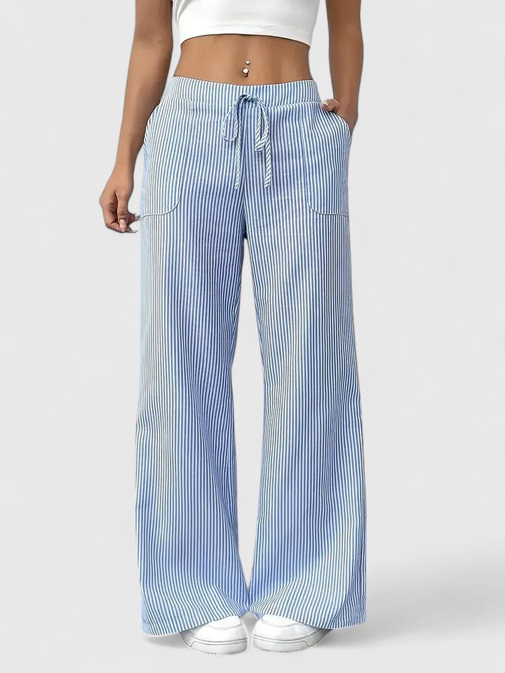 Pantalon large élégant Dominique de Danoir Paris, tissu fluide, coupe raffinée, porté avec une blouse blanche.
