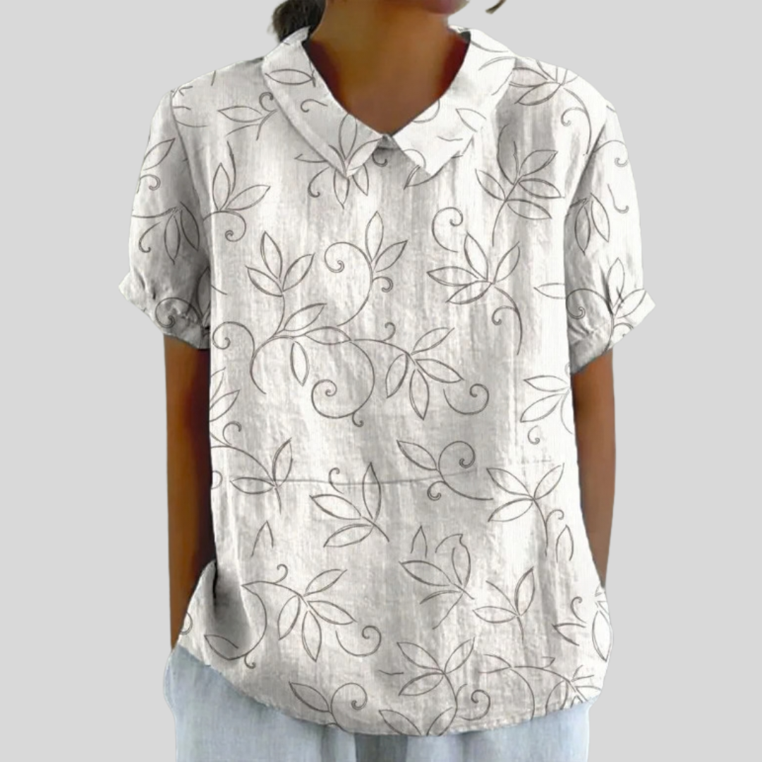 Blouse minimaliste Édith de Danoir Paris avec motif feuillage, en tissu léger et élégant, portée sur un fond neutre.