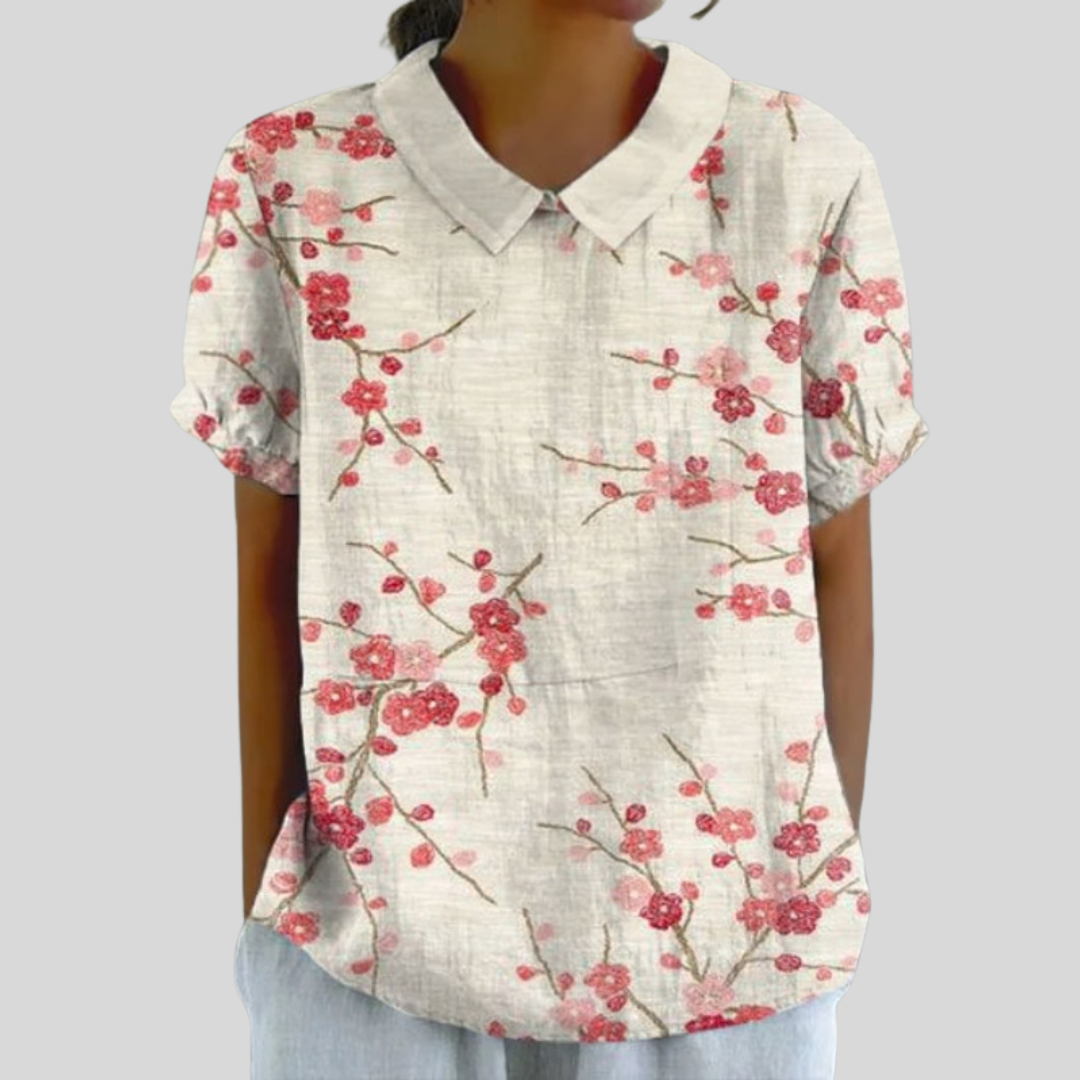 Blouse fleurie épurée Danoir Paris, en coton léger avec manches longues et col en V, motif floral coloré sur fond blanc.