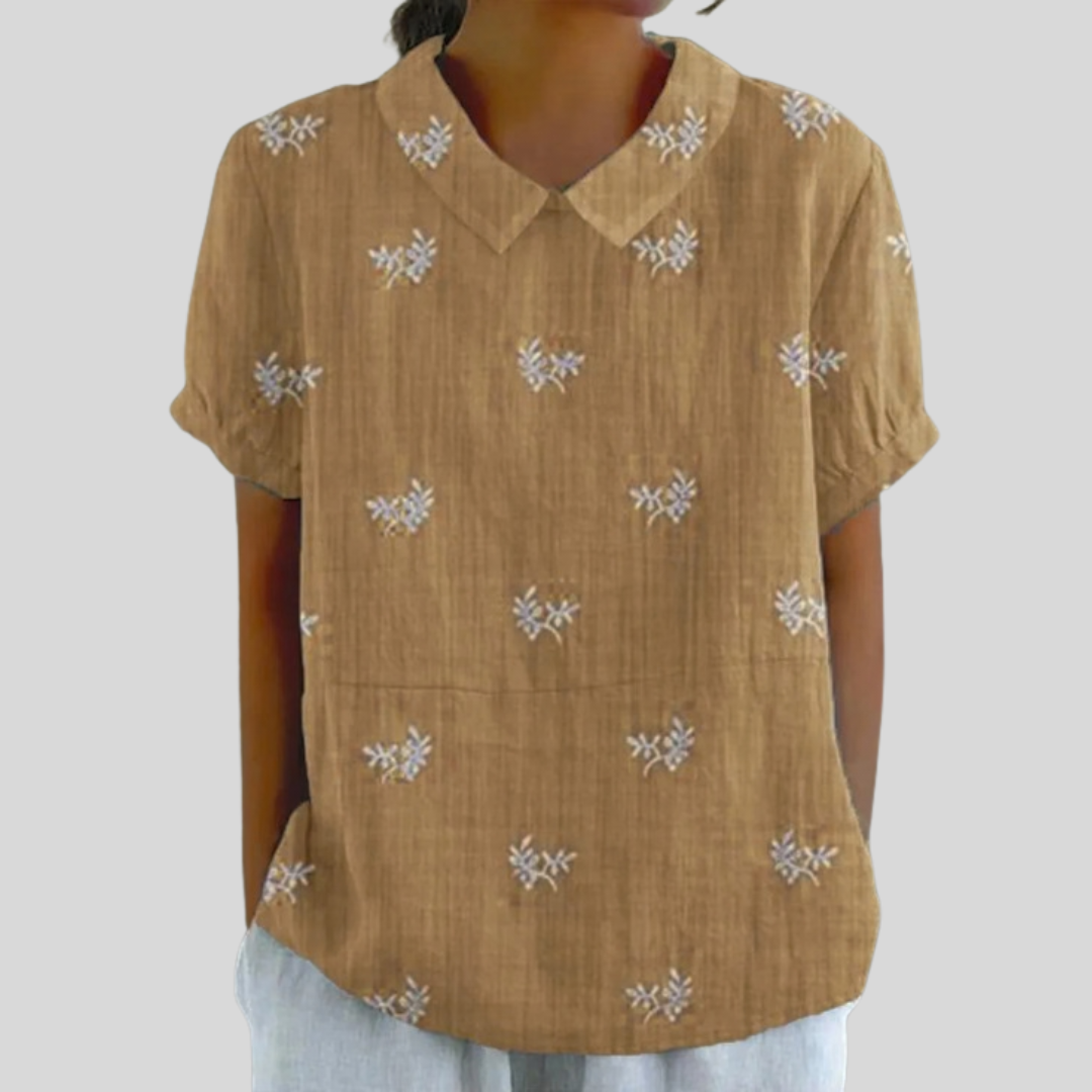 Blouse brodée discrète Geneviève de Danoir Paris, en tissu léger avec détails de broderie fine, portée élégante.