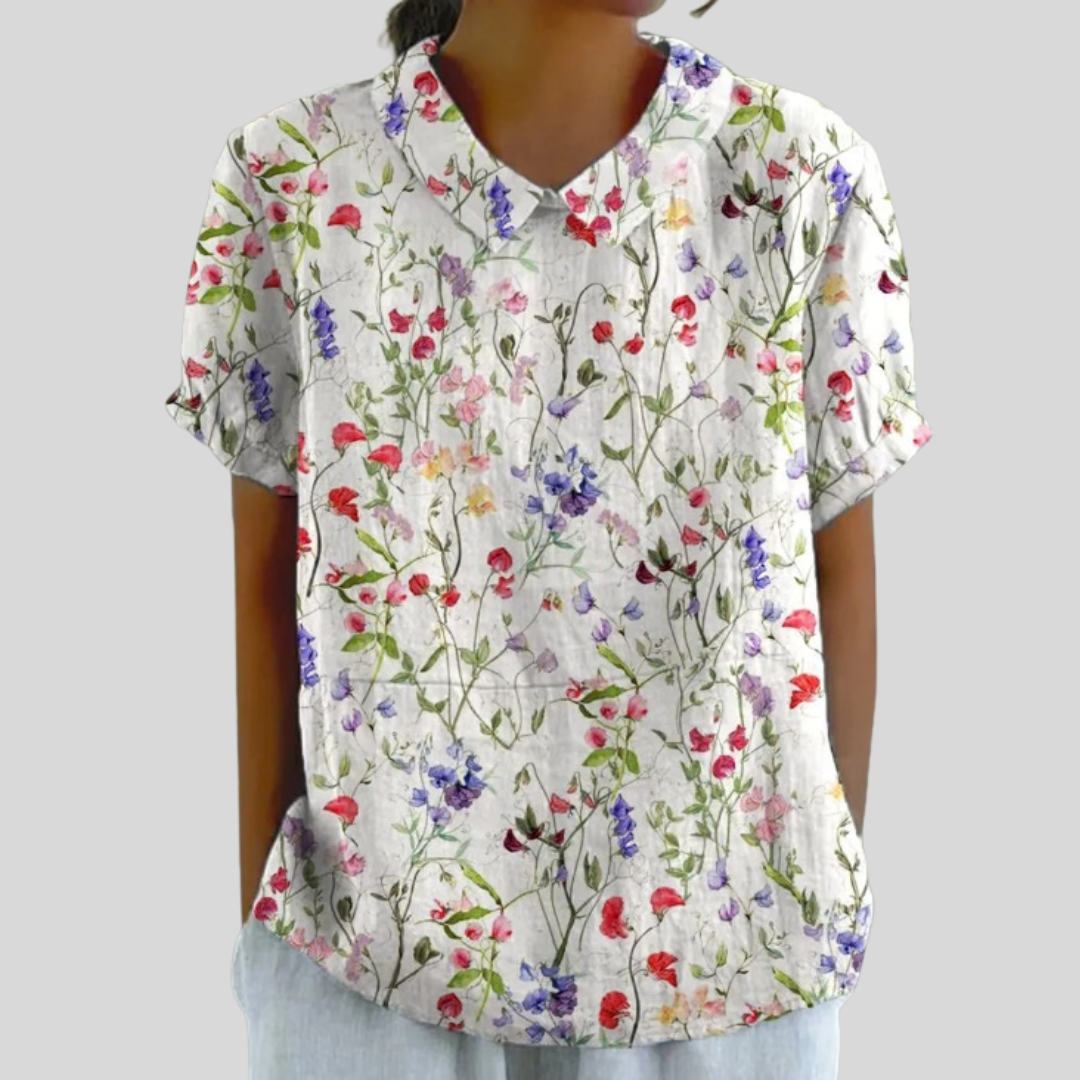 Blouse florale légère Océane de Danoir Paris portée par une femme, design fluide et élégant, fond blanc avec motifs floraux colorés.