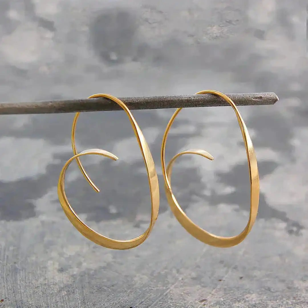 Boucles d'oreilles pendantes en spirale ouverte en argent de Danoir Paris, élégantes et modernes.