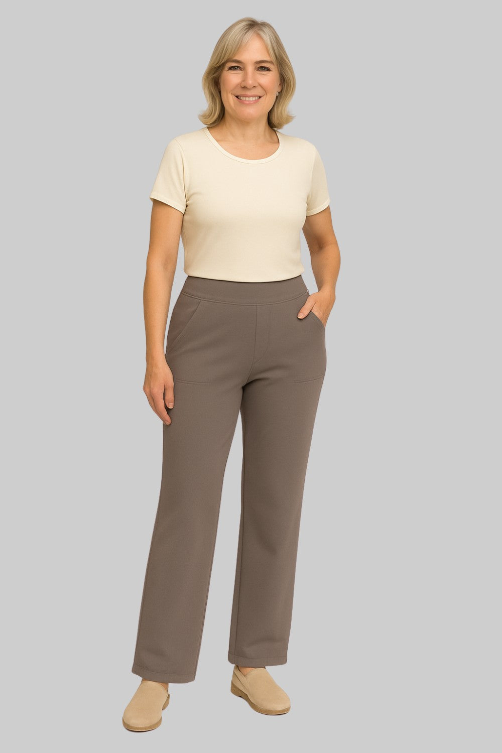 Pantalon stretch confortable pour femme de Danoir Paris, femme portant un pantalon taupe dans un studio.