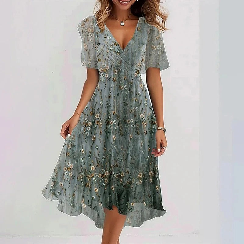 Robe florale élégante Danoir Paris Yara avec motifs colorés et coupe fluide, portée sur mannequin dans un décor lumineux.