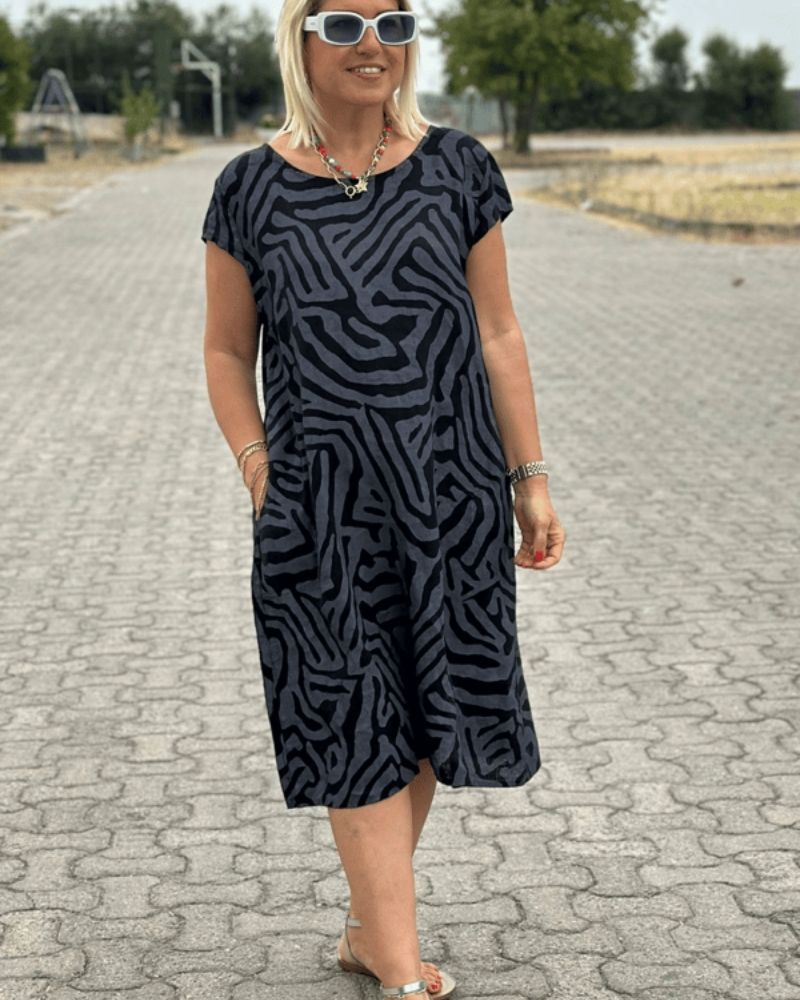 Robe d'été Nelia de Danoir Paris avec col rond et imprimé floral, portée en style décontracté.