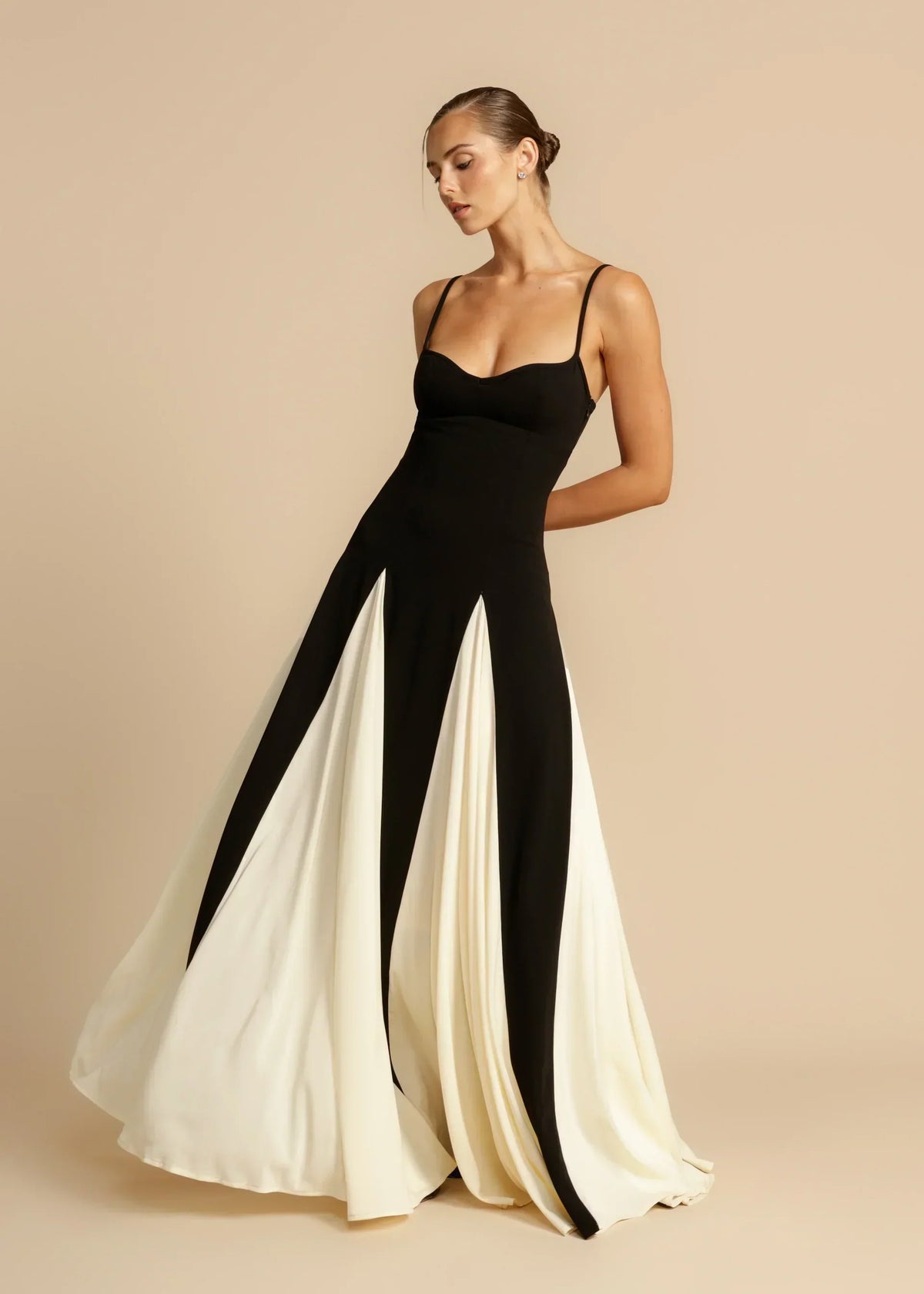 Robe longue élégante Sandra de Danoir Paris, en tissu fluide, couleur neutre, portée avec manches longues et décolleté sophistiqué.