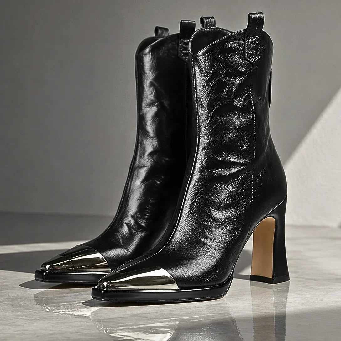 Bottines western Ambre de Danoir Paris avec bout métallisé, en cuir camel et semelle en caoutchouc sur sol en bois.