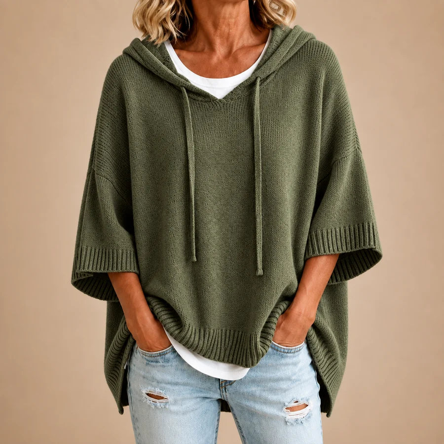 Poncho en tricot avec capuche bleu marine de Danoir Paris, détail de la texture douce et élégante en tissu chaud.