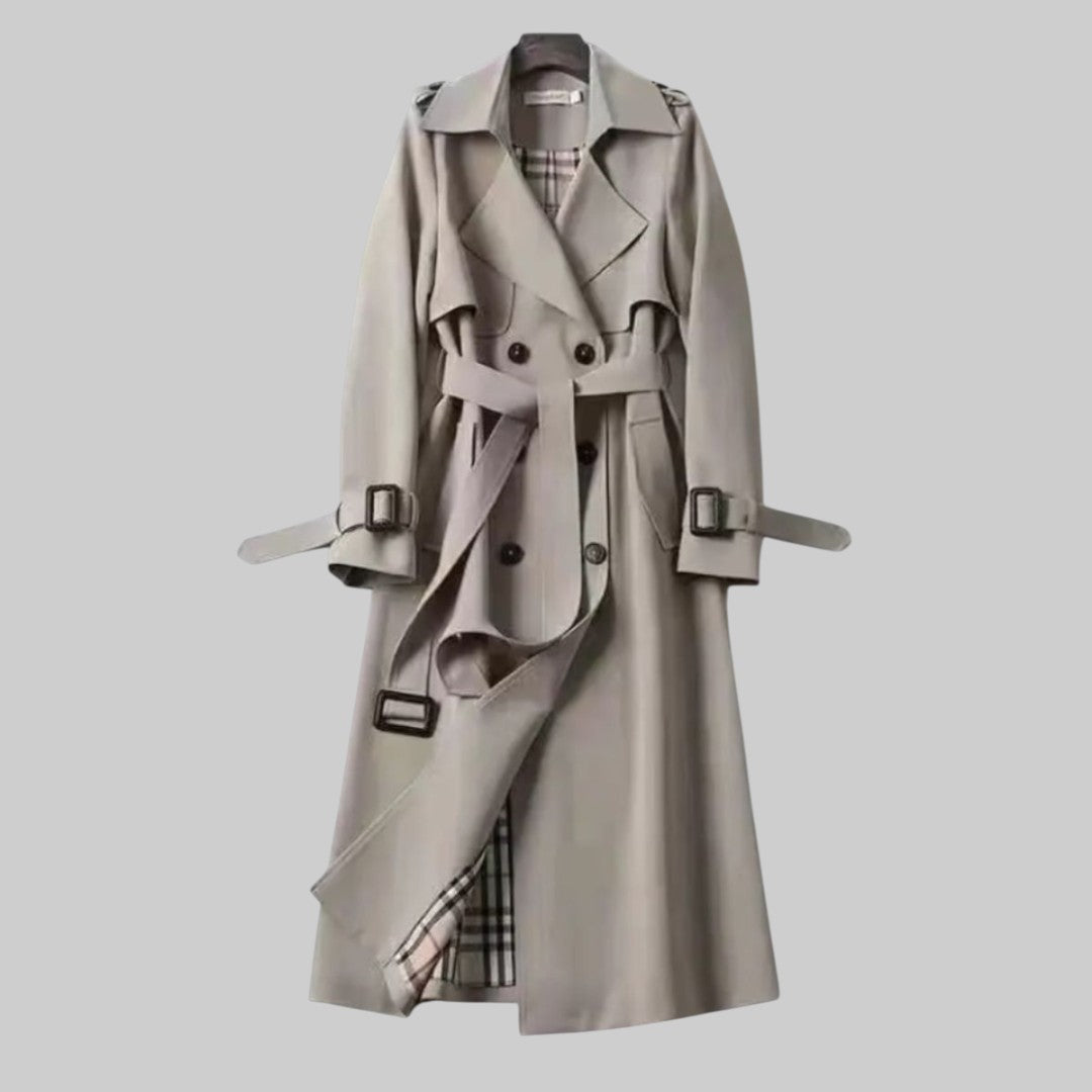 Trench-coat classique Jakarta™ de Danoir Paris en tissu beige, avec ceinture et manches longues, porté par une mannequin.